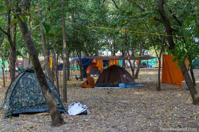 monk sitting next to his tent