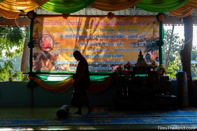 monk unrolling a rug