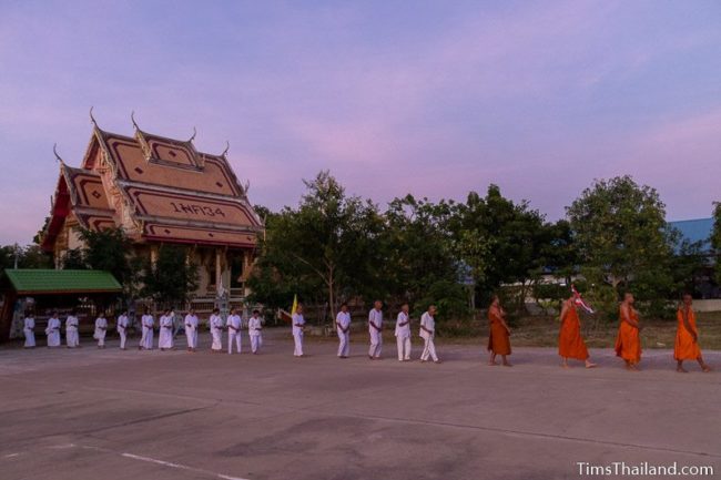 monks and people in white doing walking meditation