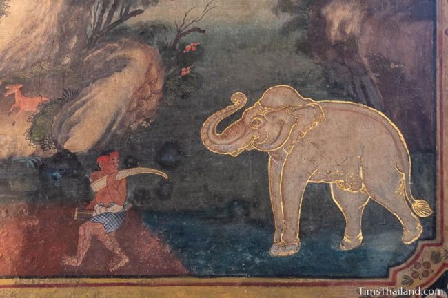mural painting of a gold-trimmed elephant and a man taking one of his tusks