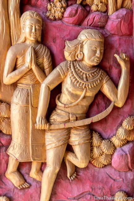 woodcarving of Angulimala running with sword