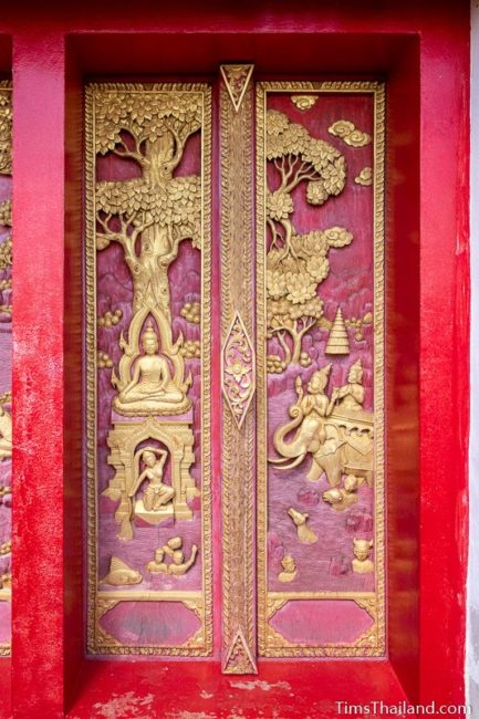 carved wood doors with Buddha battling Mara