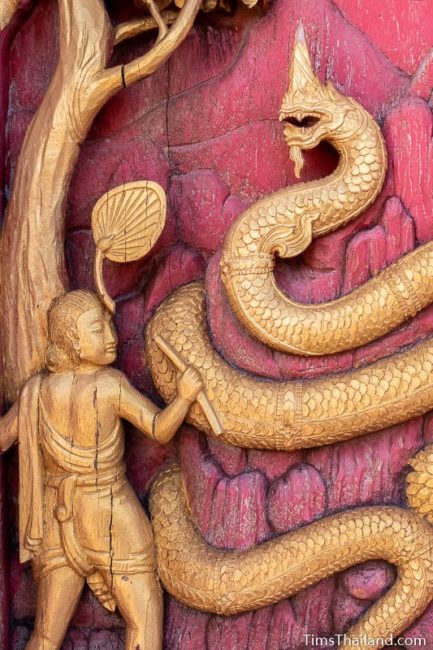 woodcarving of a man and a naga