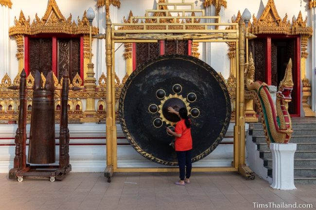 woman rubbing a large gong