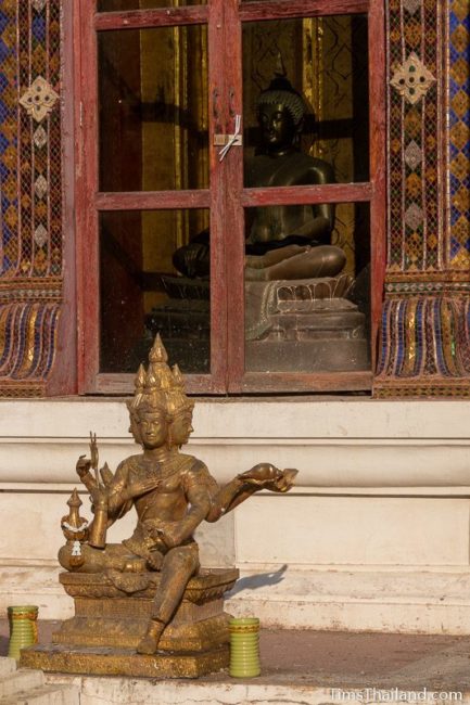 Brahma statue in front of a Buddha statue