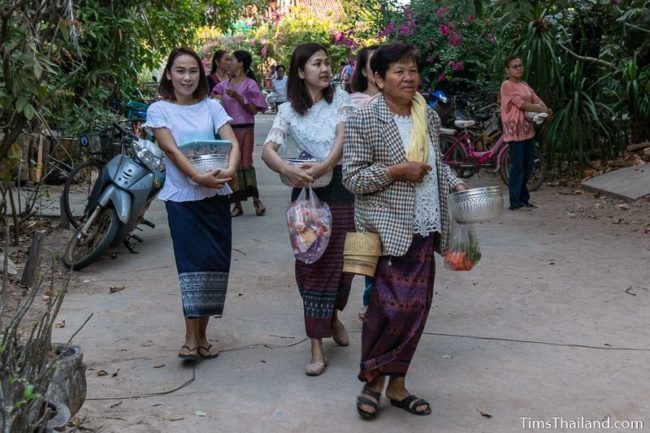 women carrying rice and food bowls