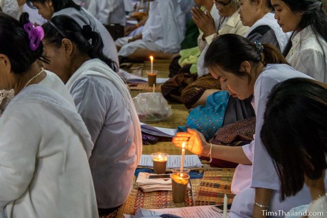 woman chanting with candle in front of her