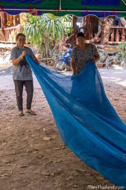 two women folding mesh fabric