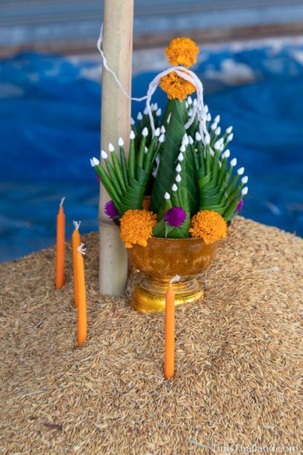 candles and bai sii on top of rice pile