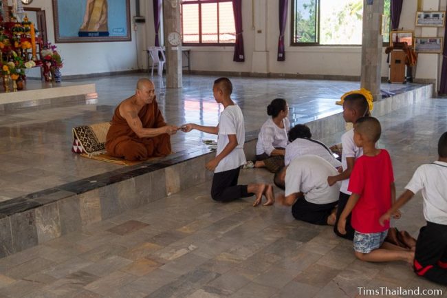 children in line to get money from monk