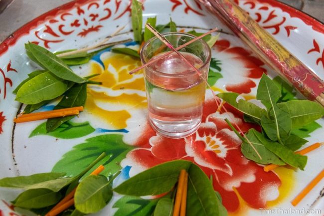 tray with water, incense, and leaves