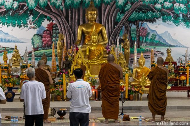 monks standing in front of Buddha image