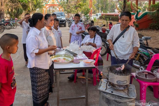 women making khao griap at the temple