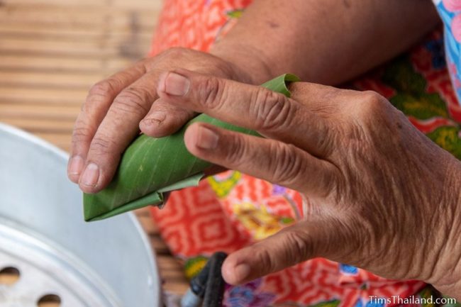 closeup of woman making khao tom mat