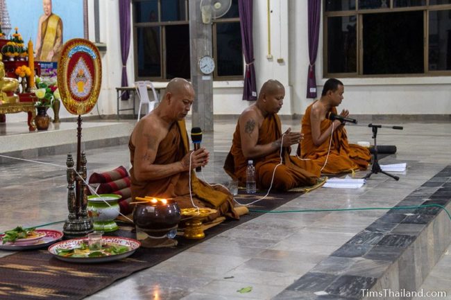 monks holding sai sin sacred thread