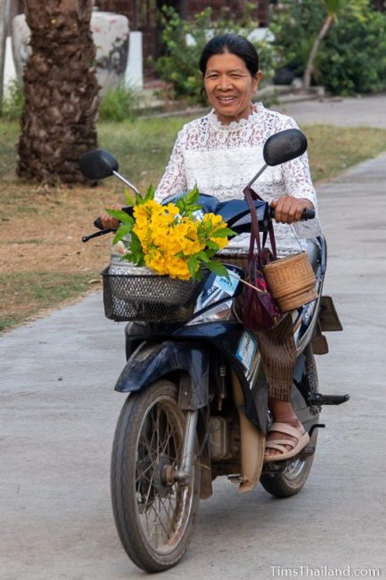 woman driving motorcycle with flowers on the front