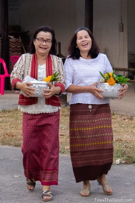 women carrying flowers and bowls