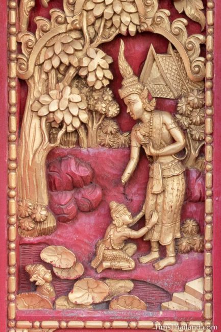 woodcarving of child crying at father's feet.