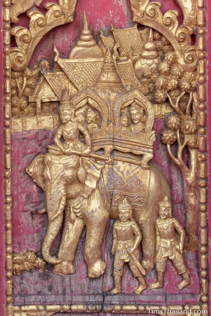 woodcarving of family riding on back on elephant.