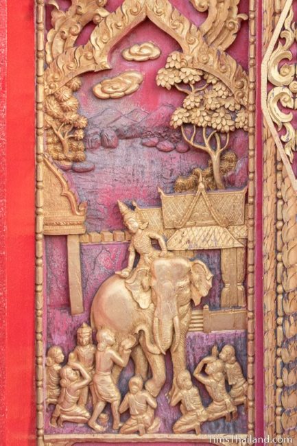 woodcarving of man riding on back of an elephant.