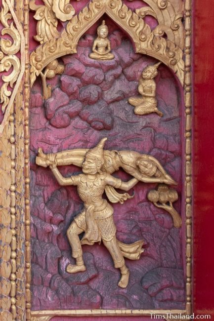 woodcarving of a goblin throwing a man over a cliff.