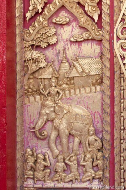 woodcarving of man riding an elephant.