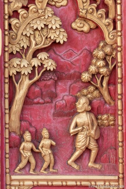 woodcarving of old man walking with two children.