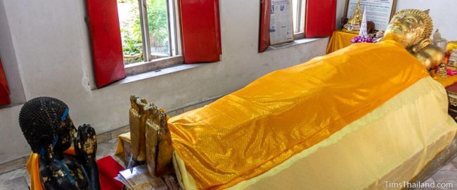 Buddha laying on his back with a worshiper at his feet