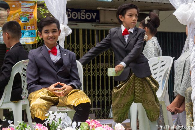 two boys in suit coats in a Khao Phansa candle parade