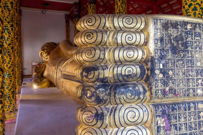 large reclining Buddha in Entering Nirvana posture with designs painted on soles of feet