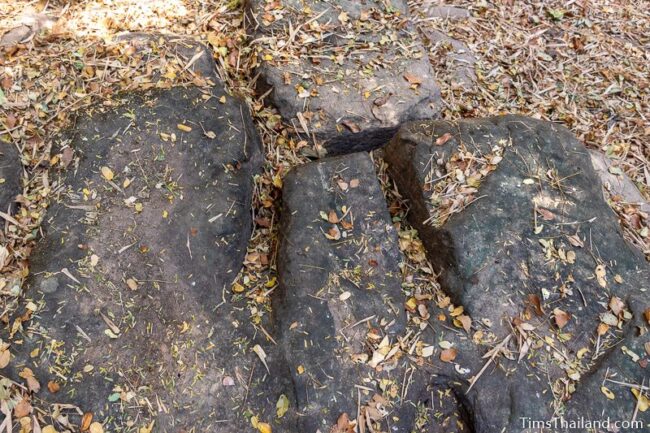 rock outcrop with blocks cut out of it