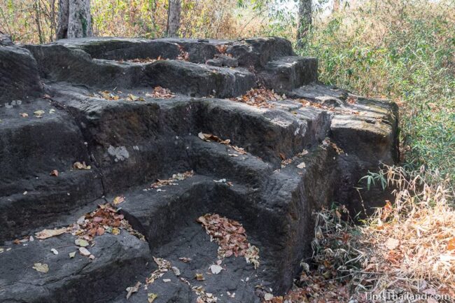 rock outcrop with blocks cut out of it