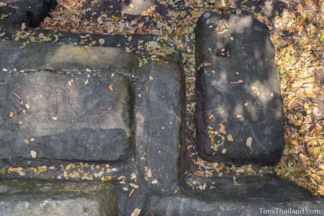 rock outcrop with blocks cut out of it