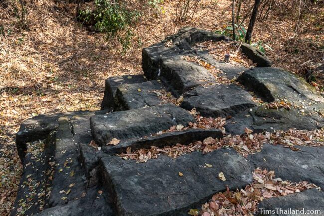 rock outcrop with blocks cut out of it