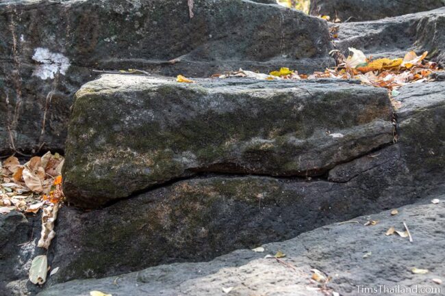 rock outcrop with blocks cut out of it