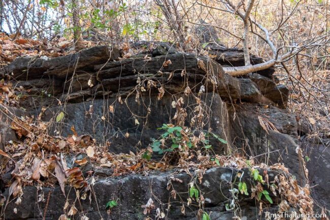 rock outcrop with blocks cut out of it