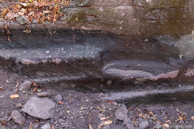 rock outcrop with blocks cut out of it