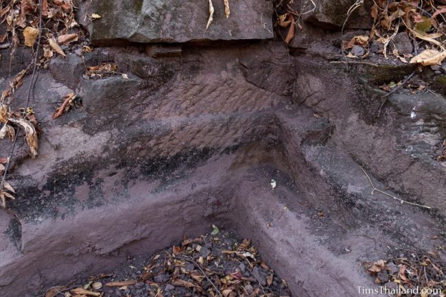 rock outcrop with blocks cut out of it