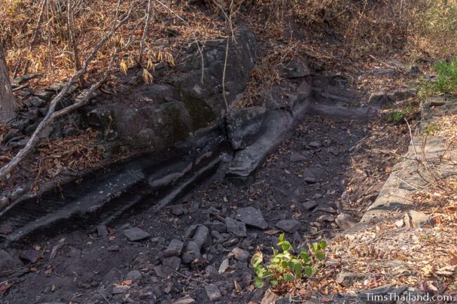 rock outcrop with blocks cut out of it