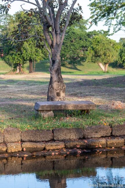 bench made of lintel next to pond