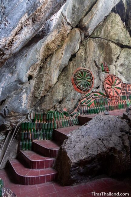 bottle art on rocks inside a cave