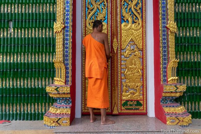 monk unlocking door to ubosot