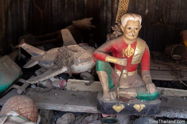 old man and plastic airplane in a shrine