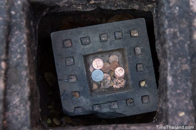 closeup of pedestal inside receptacle with coins in it