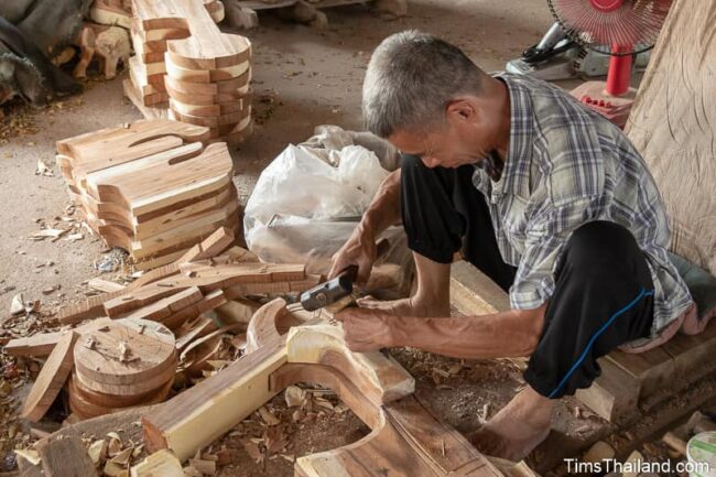 man carving wood