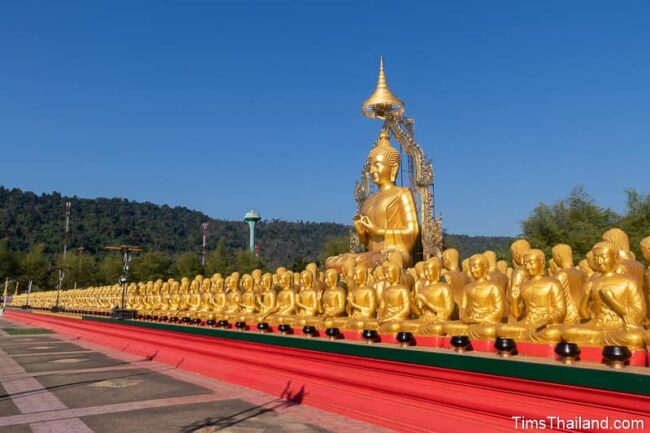 grande statue de Bouddha entourée de plus petites statues de moine