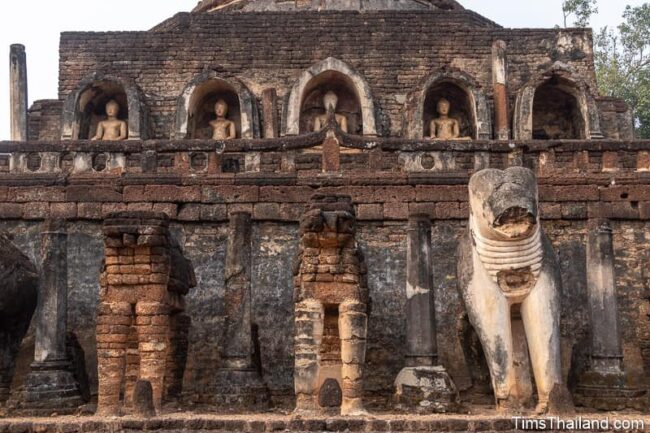 Buddha and elephant statues at base of ancient stupa