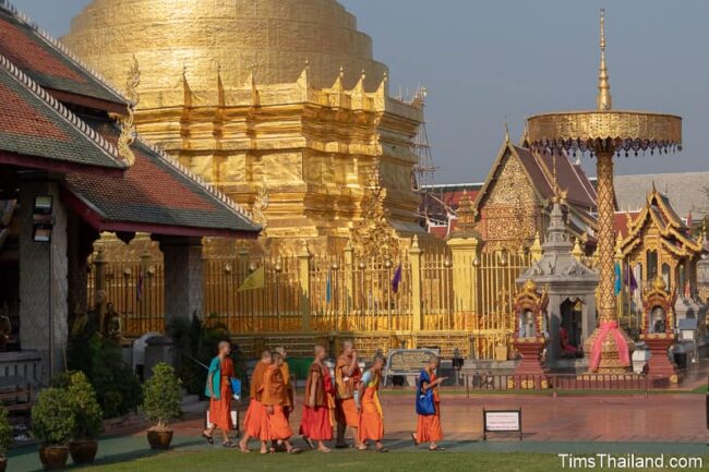 novices walking in front of stupa