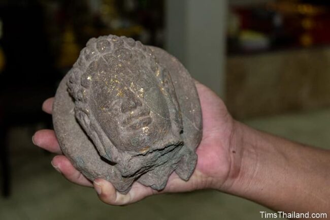 hand holding a Buddha image head