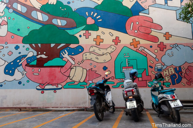 motorcycles parked in front of large mural